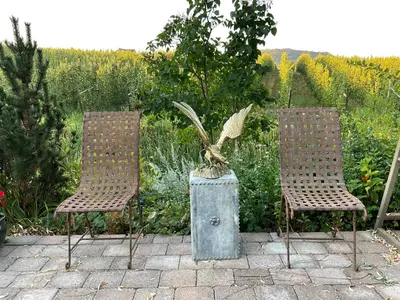 two chairs and a statue in a garden at Blackbird Glen Bed and Breakfast, Glenmore, Kelowna, BC in Kelowna