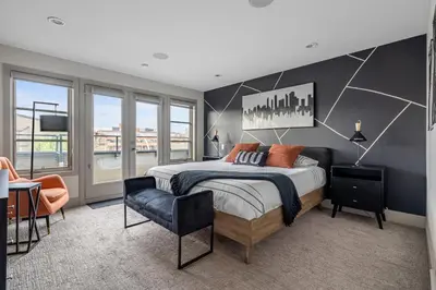a bedroom with a large bed and a chair at Rare Find, Double King Beds, Cozy and Vibrant in Calgary