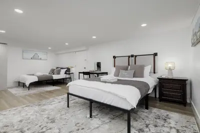 a bedroom with a large bed and a desk at Cozy BSMT suite Near UBC, Kits, and DT Vancouver in Vancouver