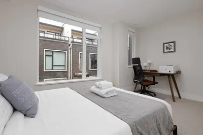 a bedroom with a bed and a desk and a window at Luxury home near DT and YVR w 2 indoor parking in Vancouver