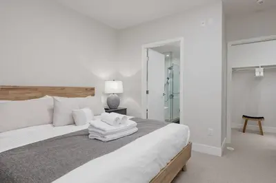 a white bedroom with a large bed with white pillows at Luxury home near DT and YVR w 2 indoor parking in Vancouver