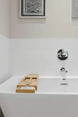 a bathtub with a wooden tray on top of it at Luxury home near DT and YVR w 2 indoor parking in Vancouver
