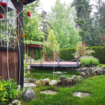 a bridge over a pond in a garden at Meadow Ridge Haven in Maple Ridge District Municipality
