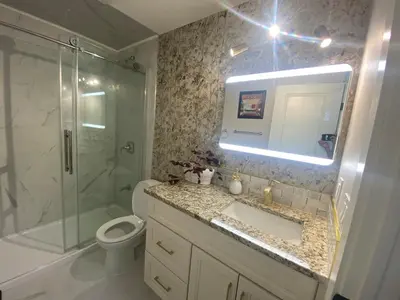 a bathroom with a sink and a shower and a toilet at Francis' Home Stay in Calgary