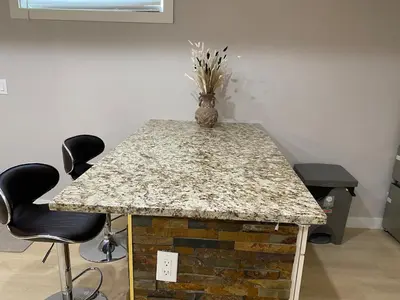 a table with two chairs and a vase on top of it at Francis' Home Stay in Calgary