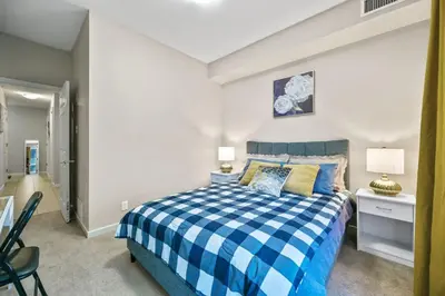 a bedroom with a blue and white checkered bed at The Urban Peak on the 19th Floor of the Alura in Calgary