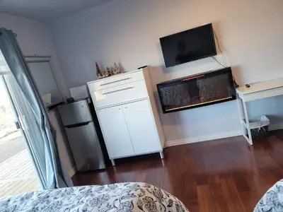a living room with a refrigerator and a fire place at HOV B&B House -Hospitality Ocean View Victoria- in Victoria