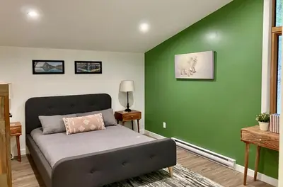 a bedroom with a bed with a green wall at Valley Edge Lodge in Golden