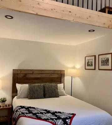 a bedroom with a bed with a wooden headboard at Valley Edge Lodge in Golden