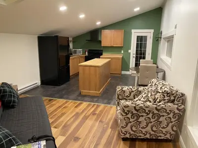 a living room with a couch and a kitchen at Bluebird Nest in Golden