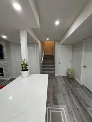 an empty room with a white counter and a hallway at HansBnB near Airport in Calgary