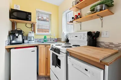 a kitchen with white appliances and a wooden counter top at Tyee Retreat Cozy Lofted 1 Bedroom Cabin in Ucluelet