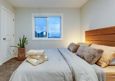 a bedroom with a large bed with a window at Neutral Living 6Beds 4Bedrooms and Bonus Room Free Parking in Calgary