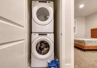 a washer and dryer in a room with a bedroom at Neutral Living 6Beds 4Bedrooms and Bonus Room Free Parking in Calgary