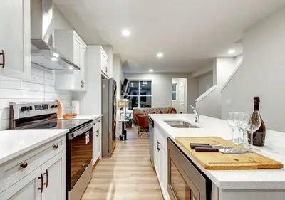a kitchen with white cabinets and a counter top at Neutral Living 6Beds 4Bedrooms and Bonus Room Free Parking in Calgary
