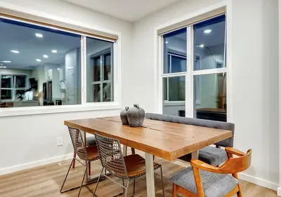a dining room with a wooden table and chairs at Neutral Living 6Beds 4Bedrooms and Bonus Room Free Parking in Calgary