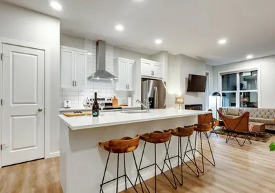 a kitchen with a counter and a bar with stools at Neutral Living 6Beds 4Bedrooms and Bonus Room Free Parking in Calgary