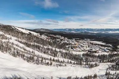 a view of a snowy mountain with trees and a town at Southpoint 25 Two Bdrm Ski In Out w Hot Tub in Big White