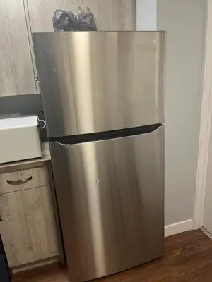 a stainless steel refrigerator sitting in a kitchen at Cozy Basement Near Airport YYC in Calgary