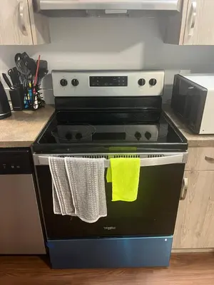 a kitchen with a stove with two towels on it at Cozy Basement Near Airport YYC in Calgary