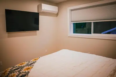 a bedroom with a bed and a flat screen tv at Courtenay Luxe Suite in Courtenay