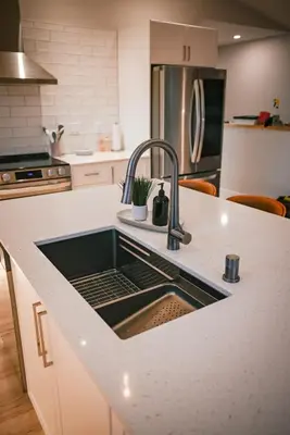 a kitchen with a sink in a white counter top at Courtenay Luxe Suite in Courtenay