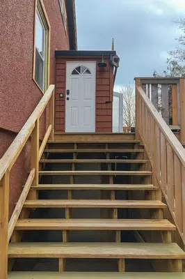 a set of stairs with a white door on a building at Quaint Attic Suite with Heated Pool Year-Round in Victoria