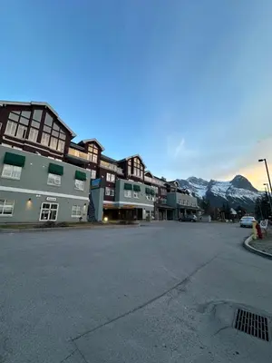 an empty street in a town with snow covered mountains at Canmore Mountain View Escape in Canmore