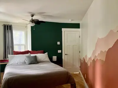 a bedroom with a bed with a green wall at Tamarack Suite in Golden