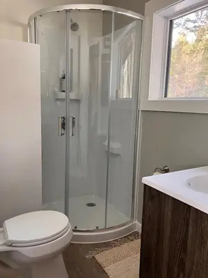 a bathroom with a shower and a toilet and a sink at Tamarack Suite in Golden