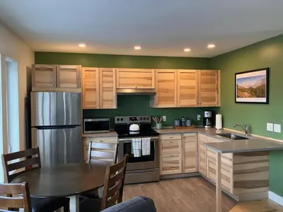 a kitchen with wooden cabinets and a table in it at Tamarack Suite in Golden
