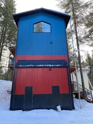 a blue and red building in the snow at Tamarack Suite in Golden