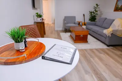 a living room with a table with a laptop on it at The Vida 1 Bed Pet-Friendly in Abbotsford