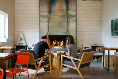 two people sitting at a table in front of a fireplace at The Vida 1 Bed Pet-Friendly in Abbotsford