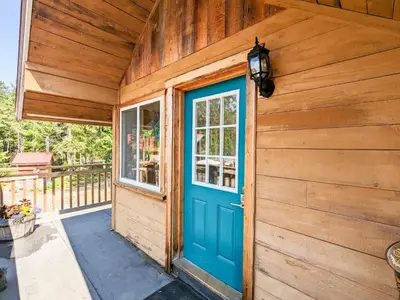 a blue door on the side of a wooden house at Quirky Farm Stay at Flower Beds Farm - Hot Tub in Qualicum Beach
