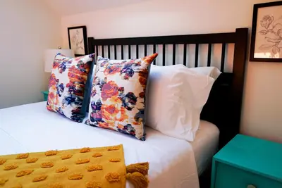 a bed with four pillows on top of it at Quirky Farm Stay at Flower Beds Farm - Hot Tub in Qualicum Beach