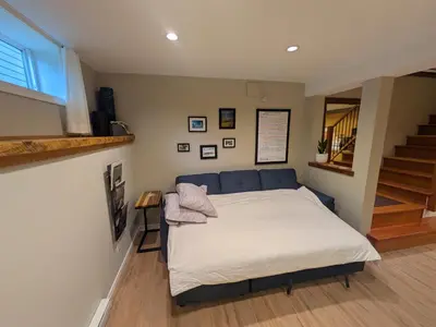 a bedroom with a bed and a staircase at Fresh Studio Apartment in Central Rossland in Rossland