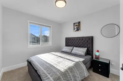a bedroom with a bed and a window at Your Pleasant stay in 3 bedroom House in Saddle-Ridge in Calgary