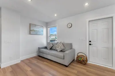 a living room with a gray couch and a window at Your Pleasant stay in 3 bedroom House in Saddle-Ridge in Calgary
