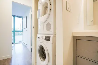 a laundry room with a washer and dryer at Yaletown Gorgeous Unit Steps from the Beach in Vancouver