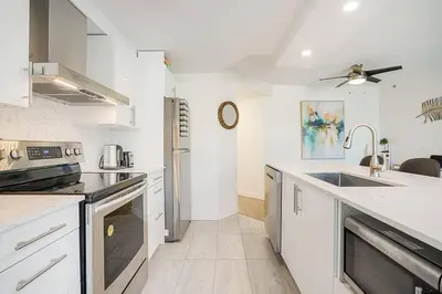 a kitchen with white counter tops and a sink at Yaletown Gorgeous Unit Steps from the Beach in Vancouver