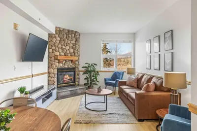 a living room with a couch and a fireplace at Charming & Cozy 1-Bedroom Retreat in Canmore