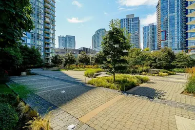 a park in a city with tall buildings at Home in the Sky with Gorgeous Water Views in Vancouver