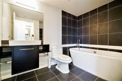 a bathroom with a tub and a toilet and a sink at Home in the Sky with Gorgeous Water Views in Vancouver