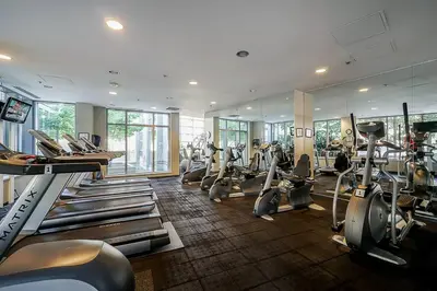 a gym with a bunch of treadmills and machines at Home in the Sky with Gorgeous Water Views in Vancouver