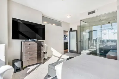 a bedroom with a large bed and a television at Urban Oasis - 2BR Condo Downtown Large Balcony in Calgary
