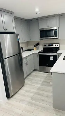 a kitchen with a stainless steel refrigerator and appliances at Private Very Spacious 2 bed 1-Bedroom basement Suite SW Calgary in Calgary