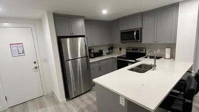 a kitchen with a stainless steel refrigerator and white counter tops at Private Very Spacious 2 bed 1-Bedroom basement Suite SW Calgary in Calgary