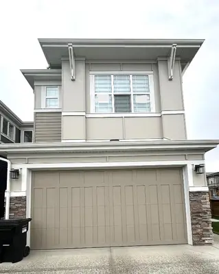 a house with a garage door in front of it at Private Very Spacious 2 bed 1-Bedroom basement Suite SW Calgary in Calgary