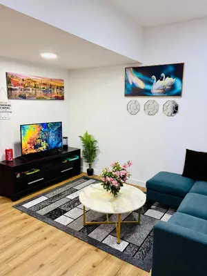 a living room with a blue couch and a tv at Charming Stay & Cozy Retreat by Bansari Homes in Edmonton- YEG in Edmonton